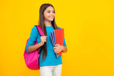 Mutlu ergen portresi. 12, 13, 14 yaşlarında kitap ve defter tutan bir kız çocuğu. Tecrit edilmiş bir geçmişi olan genç bir kız öğrenci. Öğrenme ve bilgi eğitimi kavramı. Gülümseyen kız