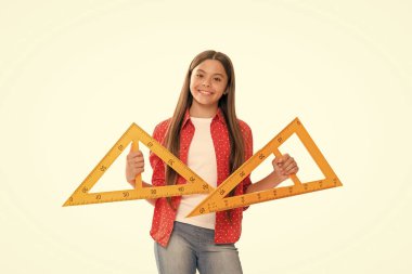 Cebir ve geometri. Çocuk matematik okuyor. Boyutunu ölçün. Trigonometri kırtasiyesi. Ölçme ve ölçme. Çocuk eğitimi. Matematik. Neşeli genç kız üçgen cetvel tutuyor. Okula geri dön..