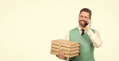 İletişim. Mutlu iş adamı klasör yığınını tutar. Güvenlik iş uzmanlığı. Adam projeyi hazırlarken akıllı telefondan konuşma yapacak. Belgeleri olan bir CEO. Patron beyaz pano ile izole edilmiş. Çok iş var..