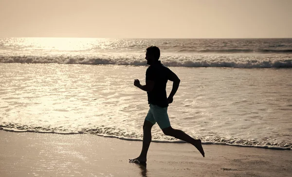 sportive man running on beach. energetic summer. runner feel freedom. hurry up. endurance and stamina. sprinter silhouette. sport athlete run fast to win in the ocean. morning workout activity.