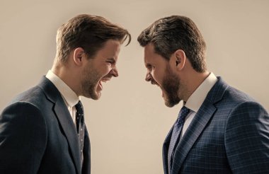 Anlaşmazlığa düşen erkek iş ortakları veya iş arkadaşları kavgaya tutuşurken agresif ve kızgınlar..
