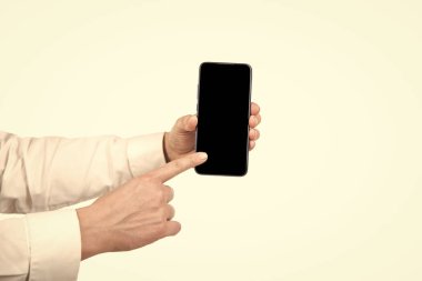 Beyaz arkaplanda izole edilmiş ve ürünü sunan ekrandaki kopyalama alanı üzerindeki el ile gösterilen telefon sunumu.