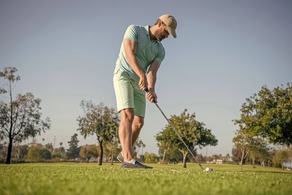 golfer in cap with golf club. people lifestyle. unshaven man playing game on green grass. summer activity. professional sport outdoor. male golf player on professional golf course.
