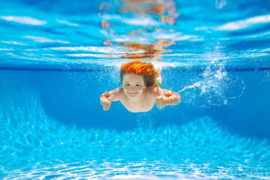 Child swim under water in sea. Kid swimming in pool underwater. Happy boy swims in sea underwater, active kid swimming, playing and diving, children water sport