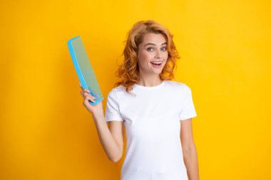 Güzellik saç bakımı. Saçlarını tarayan güzel bir kadın. Güzel görünümlü, çekici, bakımlı, neşe dolu tarağının portresi. Sarı arka planda saç efekti keratini izole edildi