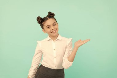 Mutlu okul çağındaki çocuk, kopya alanı mavi arkaplanı ve satışı için açık elini göster.