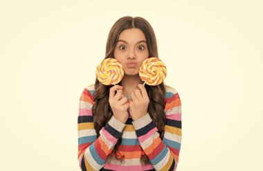 Renkli süveter giyen komik çocuk lolipopu tut. Çubukta şeker. Karamelli şeker dükkanı. çocukluk. Genç diş bakımı. Tatlı düşkünü. Lezzetli. Komik kız lolipopu beyaza izole edilmiş. Lolipop çocuk..