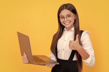 typing school blog. impact of computer on vision. kid in glasses. teen girl use laptop for communication. modern education. back to school. happy child study online. computer vision syndrome. thumb up