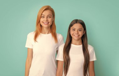 Neşeli anne ve kızı. Anne ve genç kız portresi. Kadın ve çocuk ellerini çaprazladı. Aile ve annelik. Arkadaşlık. Mutlu çocukluk. duygularını ifade et.