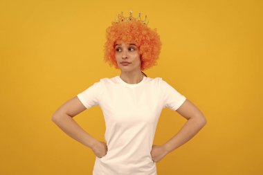 Kıvırcık palyaço peruğu ve kraliçe tacı takmış, parti ve bencillik için mutlu, bencil kadın..