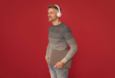 Uzaktan bile olsa e-eğitim. Kulaklıklı mutlu adam dizüstü bilgisayar tutuyor. E-eğitim ve e-okul. Online eğitim. Mesafe. Yeni bir e-öğrenme yöntemi keşfedin.