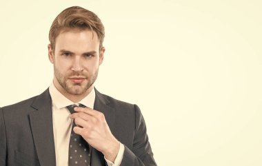 Portrait of serious professional man adjusting necktie in formal business suit isolated on white copy space, guy.