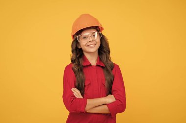 Keyfim yerinde. İşçi bayramı. Çocukluk gelişimi. Koruyucu gözlüklü genç kız. Çocuk gözlük ve kask takıyor. Koruma. Çocuk gelecekteki mühendis. Onarım için güvenlik gözlükleri.