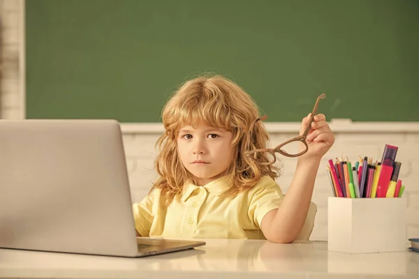 回学校去知识日 网络教育的概念 带着笔记本电脑戴眼镜的书呆子孩子 九月一日电子学习 在电脑上学习的孩子 严重的十几岁男孩在课堂上 — 图库照片