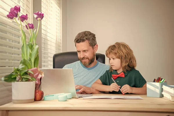 mature man teacher or dad helping kid son with school homework on computer, childhood.