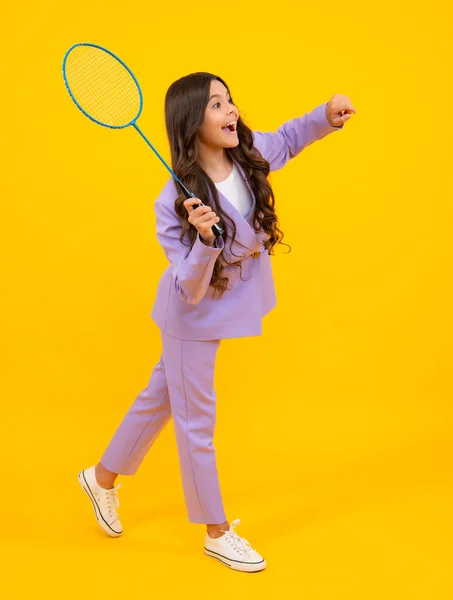 Teen girl badminton player with badminton racket isolated on yellow background