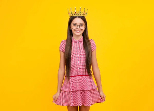 Teen child in queen crown isolated on yellow background. Princess girl in tiara. Teenage girl wear diadem