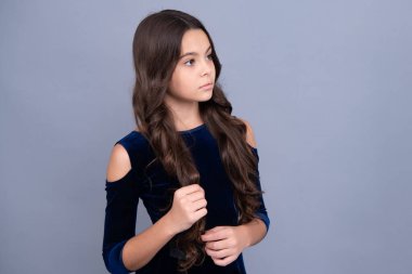 Gri arka planda çocuk stüdyo resmi. Çocukluk yaşam tarzı konsepti. Sevimli genç kız yüzü. Yakından.