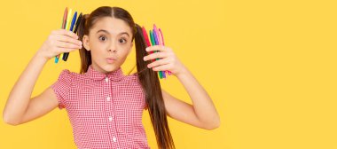 funny child girl hold colorful pens or markers for studying, school. Banner of schoolgirl student. School child pupil portrait with copy space