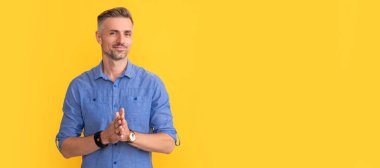 Sarı arka planda kol saati olan gülümseyen adam, moda aksesuarı. İnsan yüzü portresi, kopyalama alanı olan pankart