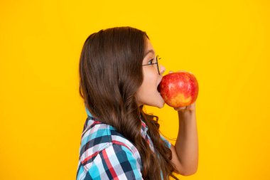 Taze meyve. Genç kız, sarı izole edilmiş stüdyo geçmişinde elmaları tutuyor. Çocuk beslenmesi