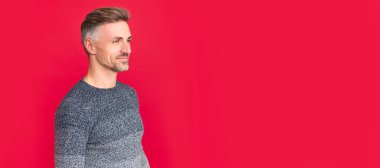 İnsan yüzü portresi, fotokopi alanı olan pankart. Kış modası. Erkek güzelliği. Saç ve cilt bakımı. Süveter giyen neşeli, kır saçlı adam