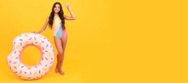 Summer child. happy girl in swimsuit inflatable doughnut ring. teen with swimming ring. Banner of summer child girl in swimsuit, studio poster header with copy space