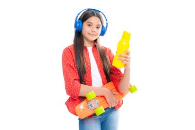 Kaykaylı su şişesi ve izole edilmiş kulaklıkları olan hippi bir kız patenci. Yaz çocukları trendi, şehir gençliği tarzı.