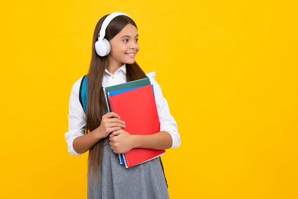 Teenager School Girl Wearing Headphones Reading Book Isolated Yellow Background — Φωτογραφία Αρχείου