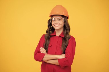 Başarılı olmak. Onarım için güvenlik gözlükleri. İşçi bayramı. Koruyucu gözlüklü gülümseyen çocuk. Çocukluk gelişimi. Neşeli genç kız gözlük ve kask takıyor. çocuk gelecekteki mühendis.