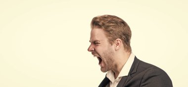 Öfke kükremesi. İş adamı öfkeyle bağırıyor. Kızgın yönetici yan yüzü beyaza izole edilmiş. Bağıran adamın profil portresi. Öfkesini ifade eder, boşluğu taklit eder..