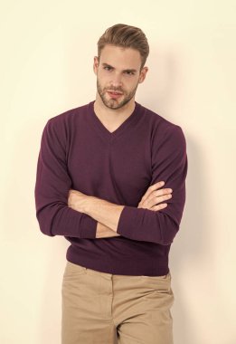 Kendinden emin ve rahat hissediyorum. Kendine güvenen bir adam kollarını çapraz olarak beyazın üzerinde tutar. Sıradan bir tarz. Moda modası. Erkek gardırobu. Moda erkek giyim. Güven ve kişisel stil için gardırop.