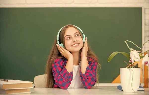 smiling child in modern earphones. online education. back to school. teen girl in headphones. music lover. listen to music. wireless headset device accessory. new technology. childhood development.
