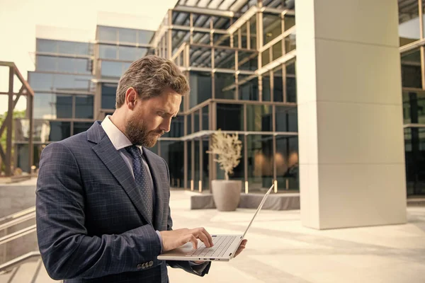 mature entrepreneur. agile business. professional network administrator hold computer. boss with modern wireless laptop. businessman working online. business success. programmer man use pc.