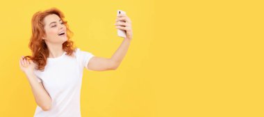 Gülümseyen kız blogcu. Mutlu kadın akıllı telefonuyla selfie çekiyor. Selfie kraliçesi. İzole edilmiş yüz portresi, taklit alanı olan pankart