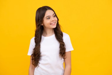 Happy teenager, positive and smiling emotions of teen girl. Emotional portrait of caucasian teenager child girl isolated on studio yellow background