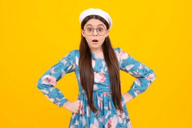 Şok olmuş ergen portresi sarı arka planda izole edilmiş. Şaşırmış genç kız. Şaşırmış yüz, şaşırmış genç kız duyguları.