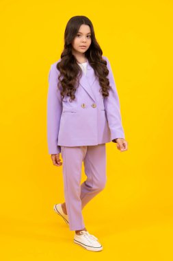 Sarı arka planda izole edilmiş rahat moda kıyafetleri giyen neşeli ergen kız çocuğu.