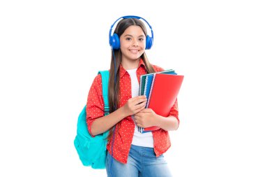 Okula dönelim. Okul çantalı kulaklıklı liseli kız öğrenci izole stüdyo geçmişi üzerine kitap tutuyor. Okul ve eğitim kavramı. Mutlu gülümseyen genç kızın portresi.