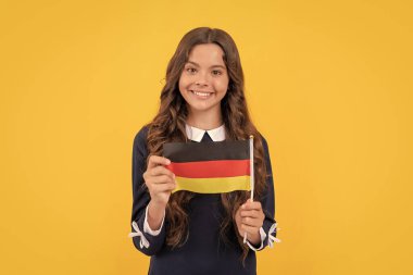 Almanya tatili. Yabancı okulda eğitim. Genç kız futbol hayranı. Mutlu çocuk Alman bayrağı gösteriyor. Schengen ülkesinde turistik vize. çocuk yurtdışına seyahat ve eğitim.