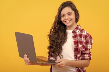 Mutlu genç kız okulda online ders sırasında dizüstü bilgisayarı tutuyor, kablosuz teknoloji..