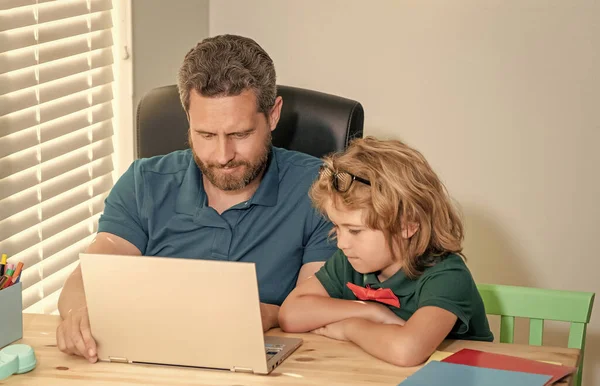 webinar video lesson. online education on laptop. homeschooling and elearning. back to school. father and son use communication technology at home. family blog. boy do homework with private teacher.