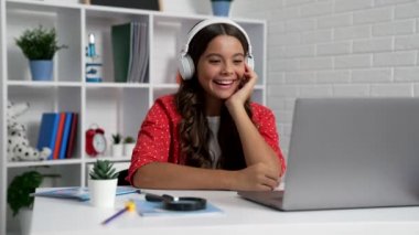 happy teen girl laughing while something funny in headphones at laptop, happiness.