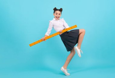 Amazed teenager. Teenager school girl study math or geometry lesson, measure the size. Mathematics ruler for measuring. Excited teen schoolgirl