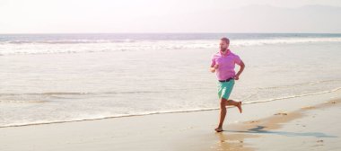 Man running and jumping, banner with copy space. healthy man running on beach. energetic summer. runner feel freedom. enjoying the morning