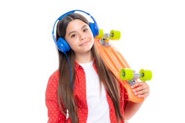 Studio shot of trendy teenage fashion model in casual look. Teenager youth hipster urban lifestyle. Child girl in street style in hipster clothes with a skateboard water bottle and headphones