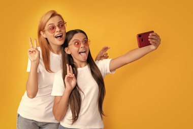 happy woman and girl take selfie with smartphone. selfie family. modern life. mobile technology. having video call. mother and daughter vlogging. online communication. mom and kid bloggers.