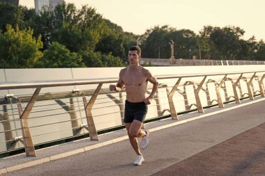 Kaslı gövdesiyle koşan sporcu..