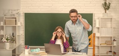 Okula dönüyorum. Çocukluk eğitimi. İnek öğrenci ve dizüstü bilgisayarlı özel öğretmen. Baba ve genç kız ders çalışıyor. Bilgisayarda özel öğretmen ve çocuk. Aile yardımı. Baba ve kızı klavyenin yanında..