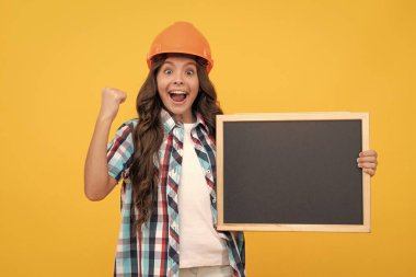 childhood education. copy space for announcement. happy workers day. happy teen girl laborer hold blackboard. child advertising labor day. back to school. kid presenting novelty information.